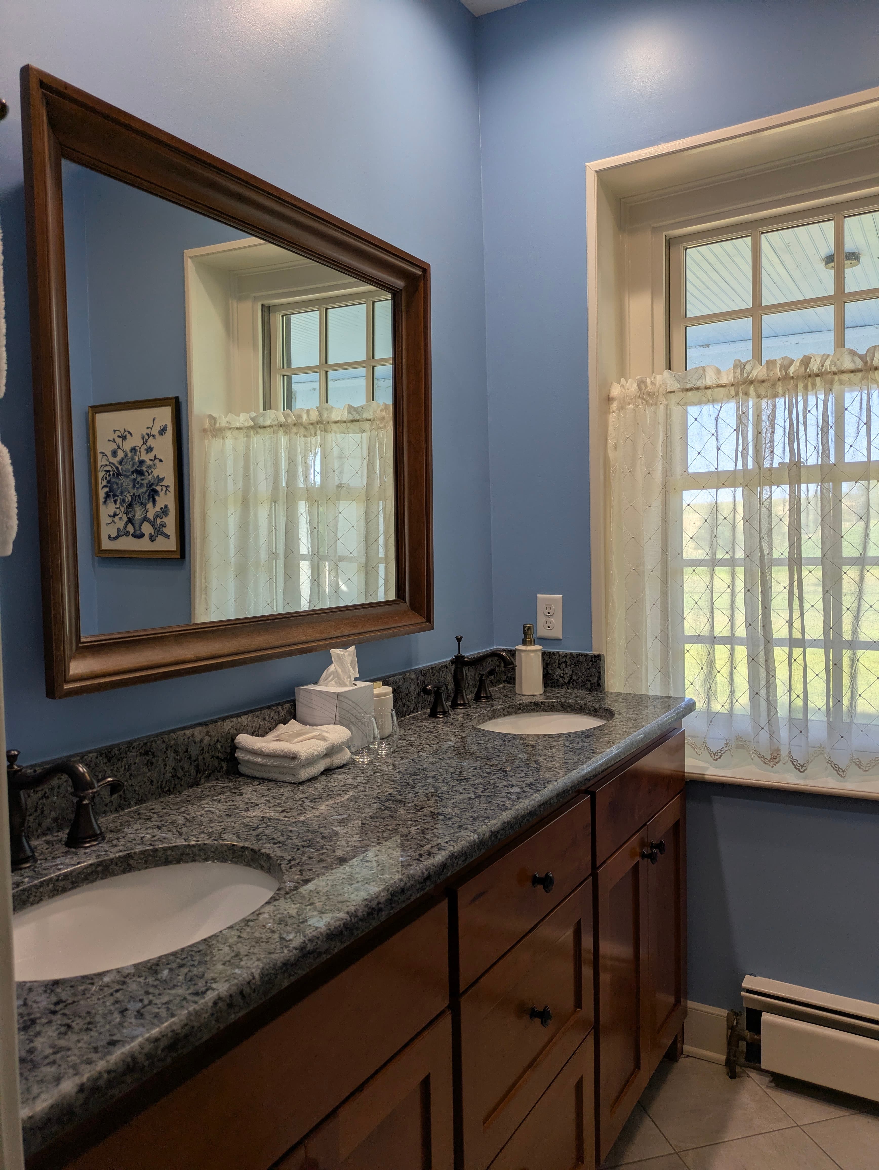 Bathroom with granite countertop and double-sink vanity, window, large mirror