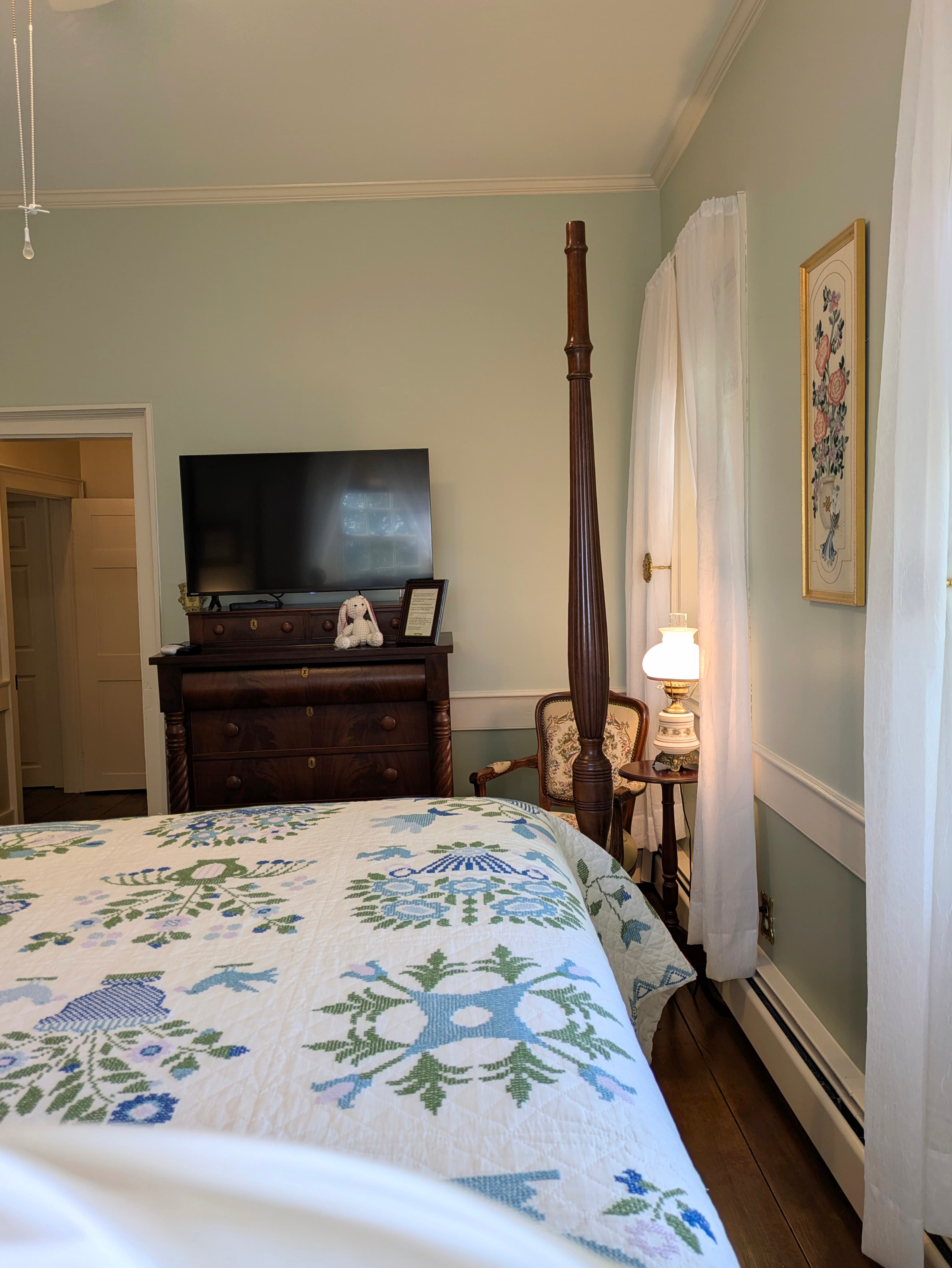 Looking back toward the door, with dresser, TV, bedroom chair with its own stand and lamp