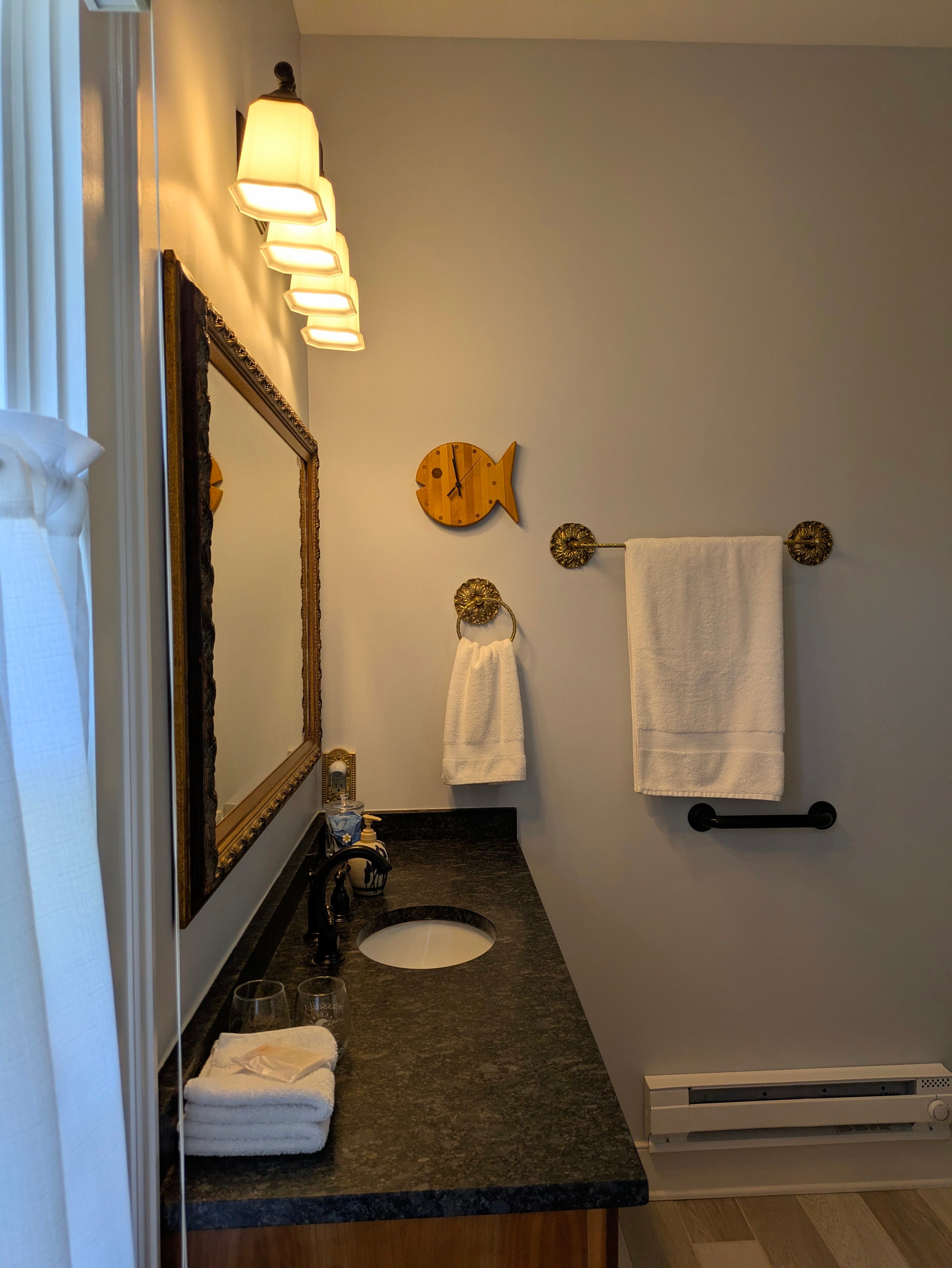 New bathroom with granite counter top, vintage towel bars, space heater, grab bar for toilet