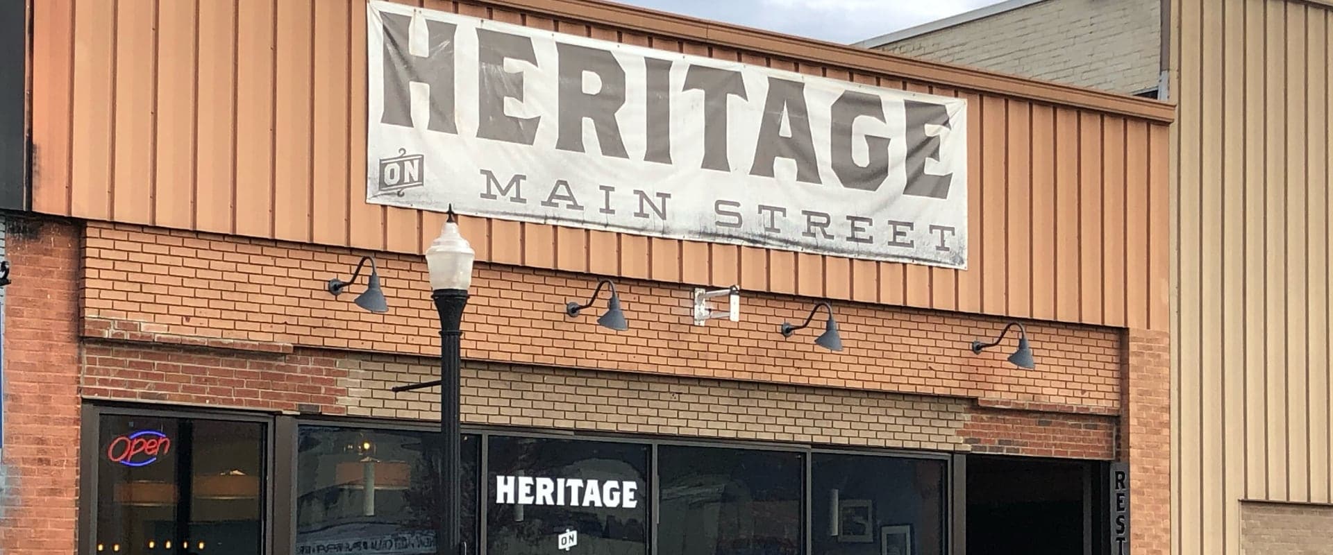 Signage for "Heritage on Main Street" above a brick storefront.