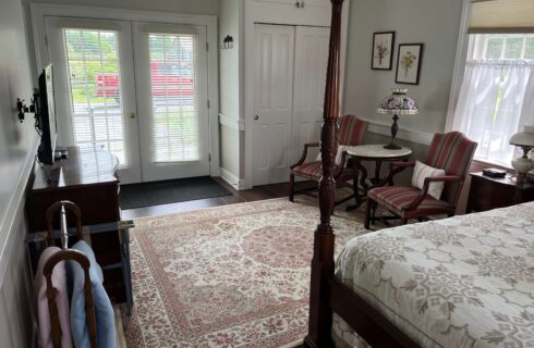 View of bedroom toward exterior door. Oriental rug, sitting area with two chairs