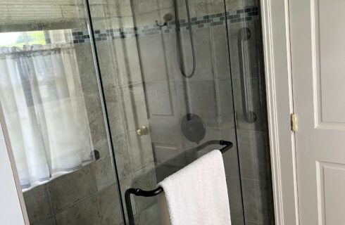 Shower with beautiful tile and white bath towel