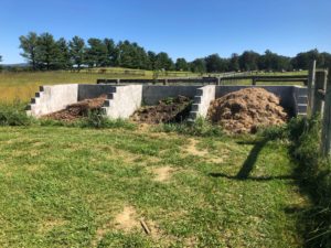 Three cinder block bins filled to different levels with compost.